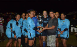 Silver Sands captain Analisa Atkinson collecting the women’s division championship trophy from co-tourney organizer Michael Atkinson following their win over Vendetta in the seventh annual Atkinson Brothers five-a-side Football Tournament