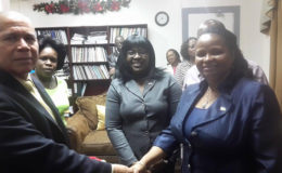 In photo Dr George Norton and Volda Lawrence (at right) shake hands while Junior Minister of Public Health, Dr Karen Cummings (at centre) and other ministry staffers look on.