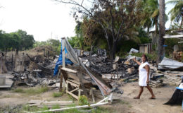 Yonnet Roberts pointing to the remains of her home.  