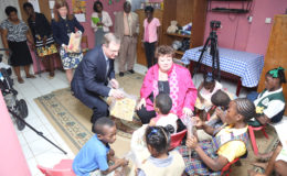 Speaker of the Legislative Assembly of British Columbia Linda Reid and a delegation who are in Guyana to sign a Partnership Agreement with the National Assembly of Guyana yesterday made a presentation of toys and books to children of the Ruimveldt Children’s Home and Care Centre. In photo, Reid interacts with some of the children while others look on. (Photo by Keno George)