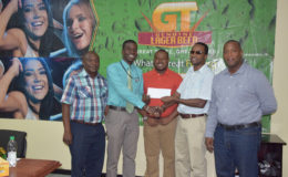 Petra Organization representative Mark Alleyne (2nd from left) collecting the sponsorship cheque from GT Beer Brand Manager Jeffrey Clement (2nd from right) while Communications Director Troy Peters (left), Petra Co-Director Troy Mendonca (centre) and Banks DIH Limited Outdoor Events Manager Mortimer Stewart (right) share the moment.
