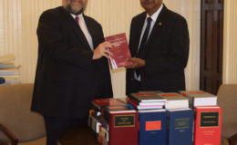 US Ambassador Perry Holloway (left) presenting the law books to Chancellor of the Judiciary, Justice Carl Singh