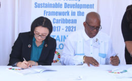 Minister of Finance Winston Jordan and United Nations (UN) Resident Coordinator Mikiko Tanaka sign the UN Multi-Country Sustainable Development Framework 2017-2021. (Photo by Keno George)