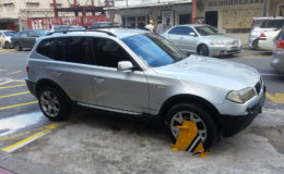 Former president Donald Ramotar’s vehicle with the wheel clamp on opposite Freedom House yesterday.