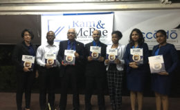 Managing Partner Christopher Ram (third from left) along with CEO of Ram and McRae Rakesh Latchana (middle) and employees holding the new handbook. 