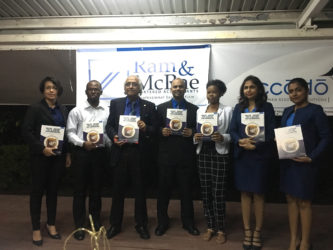 Managing Partner Christopher Ram (third from left) along with CEO of Ram and McRae Rakesh Latchana (middle) and employees holding the new handbook. 