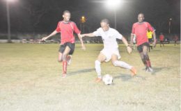 Job Caesar (centre) of Santos trying to maintain possession of the ball while being pursued by two Riddim Squad players during their semifinal at the GFC ground in the Stag Nations Cup