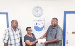 Gail Doris, Director of Human Resources, management and Development of the Guyana Water Inc., presents the sponsorship cheque to Rose hall Town Youth and Sports Club’s Hilbert Foster, while at right, Fohan Harry also of the RHTY&SC looks on.
