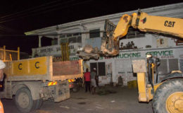City Hall last evening carried out an operation at Rams Auto Spares and Trucking Service located at Light Street, Alberttown during which several pieces of heavy-duty machinery and spare parts that were on the reserves around the business premises were removed.
Town Clerk, Royston King who was present while the operation was being carried out told Stabroek News that the removal of the items is part of a reclamation effort on spaces under the jurisdiction of the city that were unlawfully occupied.
He said that the owner of the business, Ram (only name given) had received several warnings and notices to remove the machinery and parts but he had refused to comply.
King added that the machinery and parts had been blocking the drainage and pathways in the area. The items removed were taken to the Council Compound located at Princes Street, Georgetown.
Spare parts being removed and placed in a truck during last evening’s operation. 