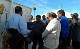 Prime Minister Moses Nagamootoo and Business Minister Dominic Gaskin and others being shown one of the solar panels.