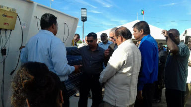 Prime Minister Moses Nagamootoo and Business Minister Dominic Gaskin and others being shown one of the solar panels.