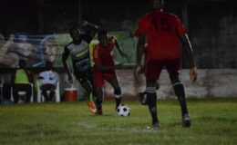 Dwayne Charles (centre) of the Guyana Police Force (GPF) trying to evade his Mahaica Determinators marker during their 2-2 stalemate at the GFC ground in the Petra Organization/Limacol Football Championship