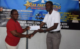 Mark Alleyne (left) of the Petra Organization collects the sponsorship cheque from Star Party Rentals representative Michelle Henry during a simple presentation ceremony held at the Craig Street, Campbellville headquarters yesterday.