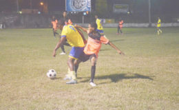 Kenneth Jackson (orange) of Camptown in the process of fouling Rene Gibbons (no.9) of Winners Connection at the GFC ground in the 2nd Annual Petra Organization/Limacol football tournament.

