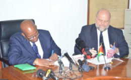 Finance Minister Winston Jordan and US Ambassador Perry Holloway signing the FATCA Agreement in October last year.
