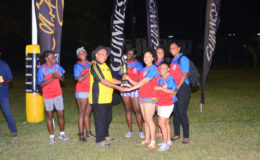 Captain of the Pepsi Hornets female rugby team Tricia Monroe, receives the trophy for the winning team from president of the Guyana Rugby Football Union, Peter Green.
(Orlando Charles photo)
