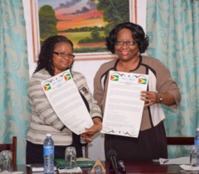  Minister of Public Health Volda Lawrence (left) and PAHO Director Dr Carissa Etienne display the signed agreements. (GINA photo)