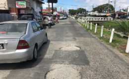 Two large holes along North Road just before the intersection with Orange Walk.
