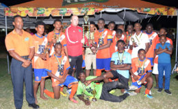Captain of the victorious Fruta Conquerors side Jeremy Garrett (centre) collecting the championship trophy from GFF Technical Director Ian Greenwood in the presence of his team-mates after defeating GFC 2-1 in the final of the inaugural Turbo Energy Drink U19 Academy Football Championship
