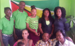 Christopher Boucher (seated, centre) with the members of the Champions of Change team. From left standing are: Leshawna Hinds, Samuel Whaul, Niki Codrington, Hadassah Caesar and Melissa Nurse. Flanking Boucher are his mother Marian Matthais (left) and Sabrina Craig, CEO of the organization.
