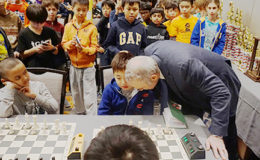 The Kasparov Chess Foundation is marking its 15th anniversary and has endorsed its commitment towards improving scholastic chess in the US. Last weekend, the Greater New York, Greater Chicago and Greater Baltimore chess tournaments were held for school-aged kids. The New York event alone attracted 1,478 players. Legendary world champion Garry Kasparov attended the event and was invited to make the first move on a number of chess boards. In the photo, a beginner chess player has the attention of the former world champion. The US boasts three players in the world’s top ten, more than any other nation. (Photo: Vanessa Sun/Chess Base)