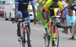 Andrew Hicks (left) secures the stage win ahead of Team Coco's Hamza Eastman yesterday in Berbice. (Orlando Charles photo)