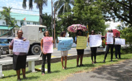 Members and supporters of Red Thread gathered outside of the Ministry of Finance yesterday. “No new taxes, we already pay and punish enuf!” and “[No] VAT on human rights” were among some of the statements written on their placards. (Photo by Keno George)
