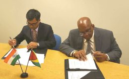 Sailesh Prasad (left), Resident Representative of the Export-Import Bank of India and Minister of Finance Winston Jordan signing the deal.