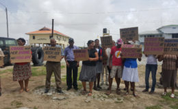 Some of the neighbours and relatives displaying placards in front of the Leonora Magistrate’s Court yesterday. Sukhwa’s daughter, Narifa Rahaman is at centre.