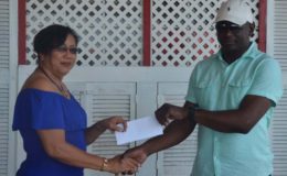 Desiree Lee receiving the cheque from Mohamed’s Enterprise representative Udoh Kanu.