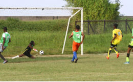 Kelsey Benjamin (2nd from right) of Chase Academy scoring one of his seven goals during his side’s record breaking 17-0 win against North Ruimveldt in the Milo u18 Secondary School Football Championships at the Ministry of Education ground yesterday. (Orlando Charles photo) 