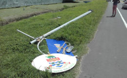 The dislodged Cayman Islands pole that was placed on the side of the road after the accident.

