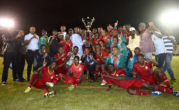 Guyana Football Federation president Wayne Forde shares in the celebration of the victorious GDF soccer team and its supporters following the final of the League Leaders tournament Sunday night at Camp Ayanganna. 