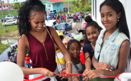 Ashley Benjamin, the daughter of Wilbert Benjamin, ceremoniously cuts the ribbon to signify the opening of the Benjamin Fitness Centre Monday at Fyrish, Corentyne. (Orlando Charles photo)