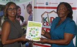 Jennifer Cipriani (left) handing over the booklets to Gayle Primo-Best
