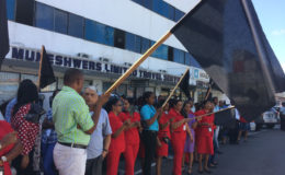 A section of the protestors gathered in front of Muneshwers on Water Street yesterday. Left, forefront is Deputy Mayor Sherod Duncan. They bore black flags to represent the mourning of the death of business activity in the city.