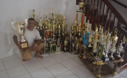 Bartica Regatta champion Dave Persaud with his numerous trophies.