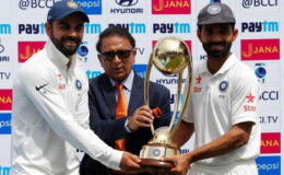 India’s Virat Kohli (L) and Ajinkya Rahane (R) receive the trophy from the former Indian cricket player Sunil Gavaskar after winning the series. REUTERS/Adnan Abidi
