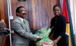 Attorney General Basil Williams SC hands over a collection of the Law Reports of Guyana to Latoya Roberts, the Best Graduating Guyanese student at the Hugh Wooding Law School for 2016.
