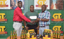 Petra Organization member Mark Alleyne (left) collecting the cheque from Banks DIH Limited Communications Director Troy Peters (right) while Petra Organization Co-Director Troy Mendonca looks on.