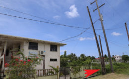 Arrow pointing to the rotted section of the GTT pole which stands just in front of one of the buildings in the compound of the Mercy Wings Vocational School in Sophia. (Photo by Keno George)