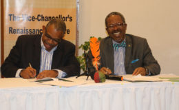 IRP Board Chairman Ian Randle (at left) and Vice-Chancellor Ivelaw Griffith during the signing last Thursday. (University of Guyana photo)