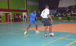 Quacey Weekes (no.17) of Agricola Champion Boys in the process of receiving a pass while being watched closely by Devon Millington (left) of Sparta Boss in their group fixture in the 2nd GT Beer/Petra Organization Futsal Championships at the National Gymnasium. 
