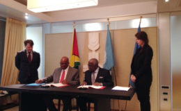 Minister of Finance, Winston Jordan (seated left) signing on behalf of Guyana.