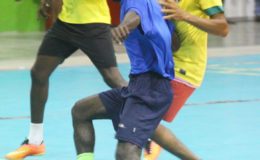 Flashback-Leon Yaw (blue) of Alexander Village battling to maintain possession of the ball while being challenged by Sheik Kamal of Sophia during their playoff fixture at the National Gymnasium in the Petra Organization Futsal Championship
