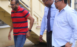 Robert Persaud (left) at SOCU on Tuesday in the company of two lawyers.