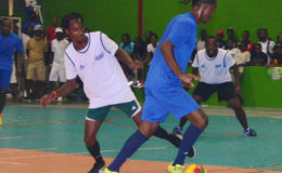 Gregory Richardson of Sparta Boss dribbling Deon Alfred of Tiger Bay at the National Gymnasium in the Petra Organization Futsal Championship.