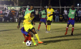 Flashback- Nicholas McArthur (yellow) of Chase Academy battling to maintain possession of the ball against a Sir Leon Lessons player during their semi-final affair at the Ministry of Education ground in the Milo Secondary School Football Championship.