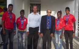  President of the Guyana Olympic Association (GOA), K Juman-Yassin and President of the Athletic Association of Guyana (AAG), Aubrey Hutson pose with some of the medalists which returned from a successful CARIFTA Games sojourn in Curacao Friday
