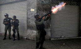  A riot police officer fires tear gas while clashing with demonstrators. (Reuters/Marco Bello)